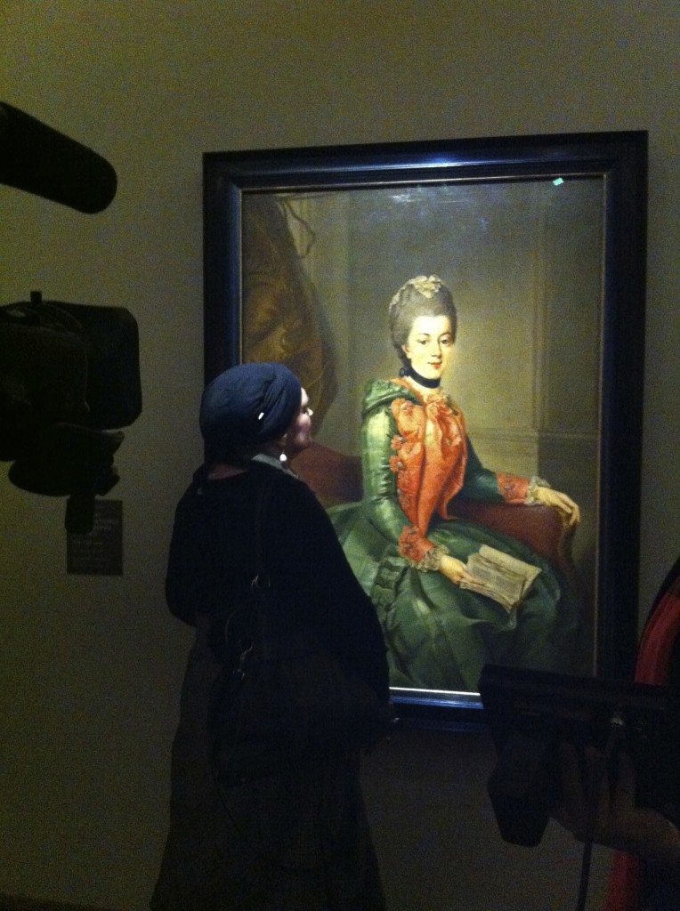 Signora con orecchino di perla posa per una televisione alla mostra di Bologna